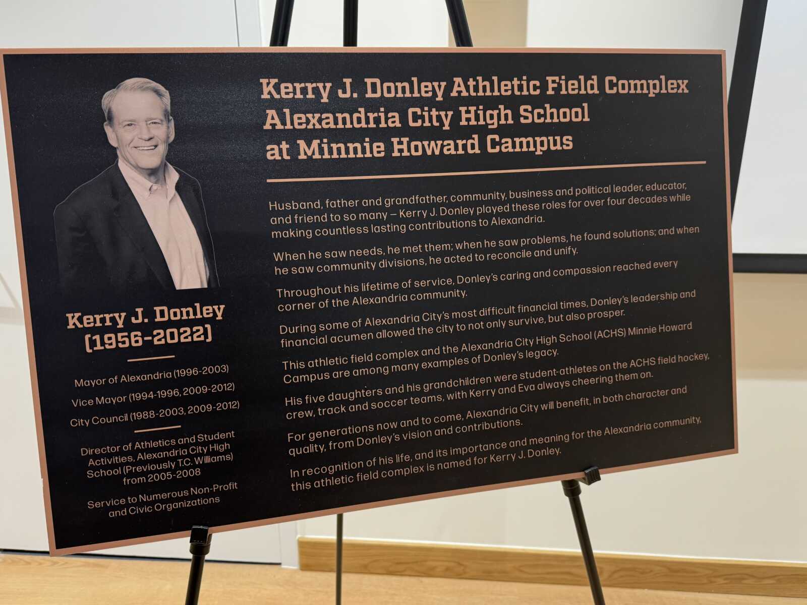 Plaque honoring Kerry J. Donley at Alexandria City High School, with his portrait on the left and a dedication text on a dark background.