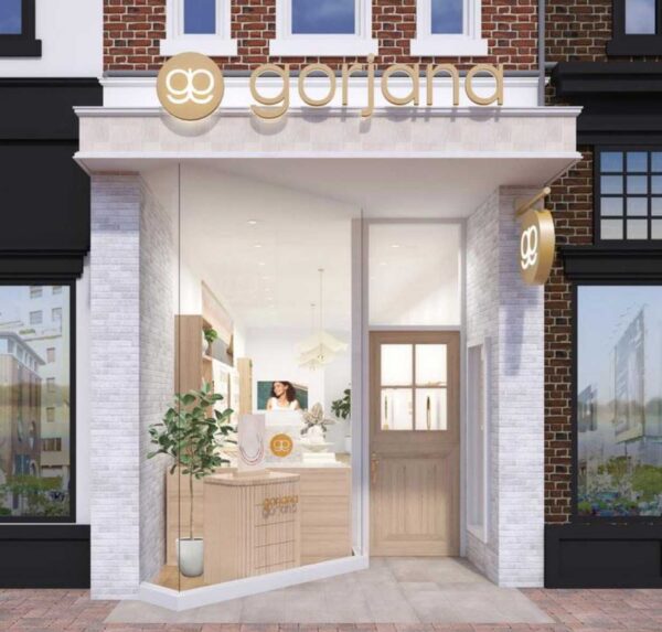 Storefront with gold 'garjana' sign and round logo above a glass-walled entry; warm, inviting interior visible inside.