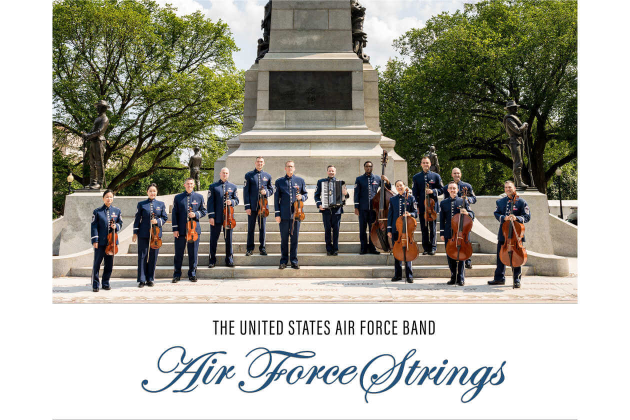 US Air Force Band: Air Force Strings ensemble posing with string instruments on steps before a stone monument.