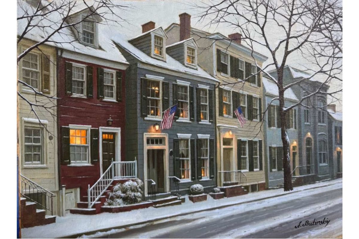 Snowy street with colorful row houses, warm-lit windows, and US flags hanging from two fronts on a quiet winter day.