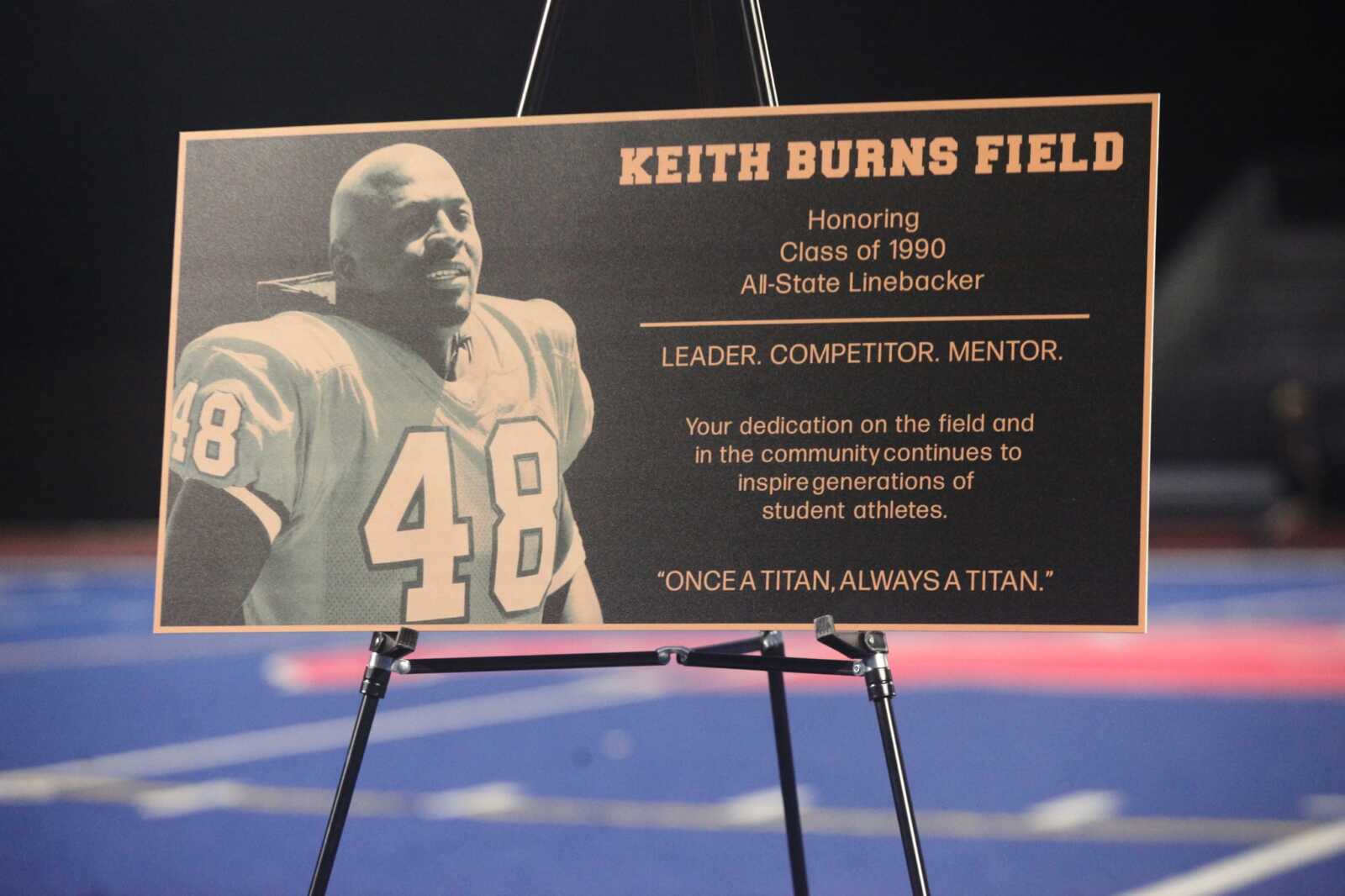 Plaque titled Keith Burns Field featuring a portrait of a football player in a jersey number 48; honors the Class of 1990 All-State Linebacker and includes the motto Leader. Competitor. Mentor.