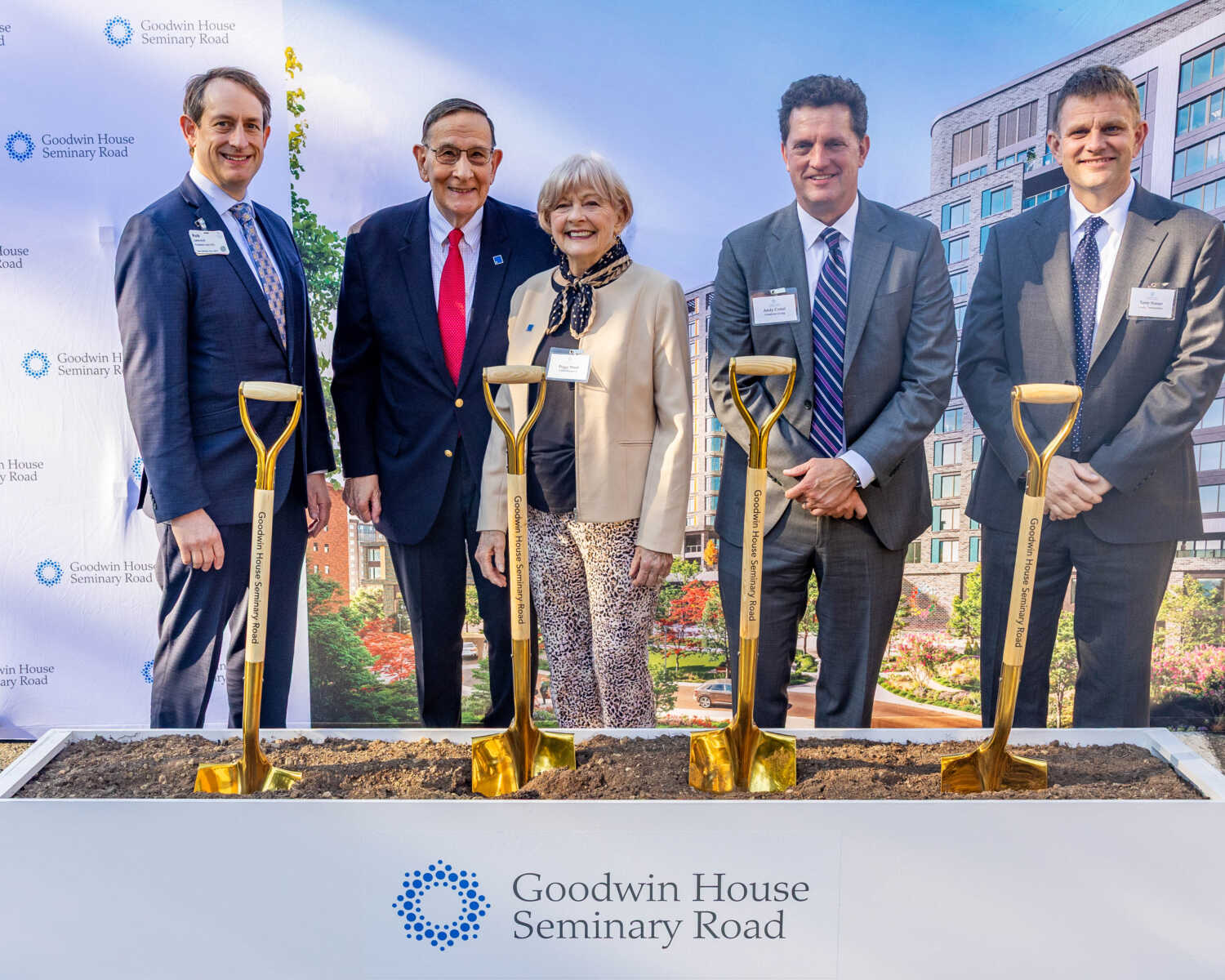 Five professionals pose with golden ceremonial shovels at a Goodwin House Seminary Road groundbreaking ceremony.