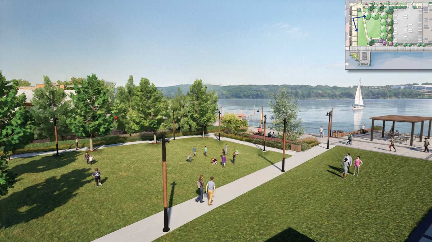 A lakeside park with green lawn, trees, paved paths, and people walking or playing near the water and a sailboat in the background. Inset map showing layout in the top-right corner.