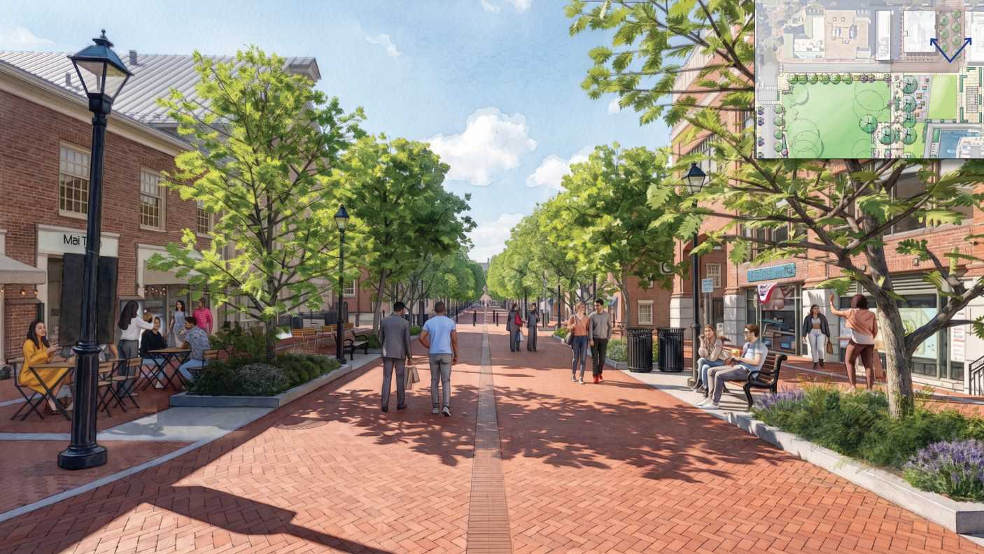 Brick pedestrian street with evenly spaced trees, outdoor café on the left, storefronts on the right, and people strolling.