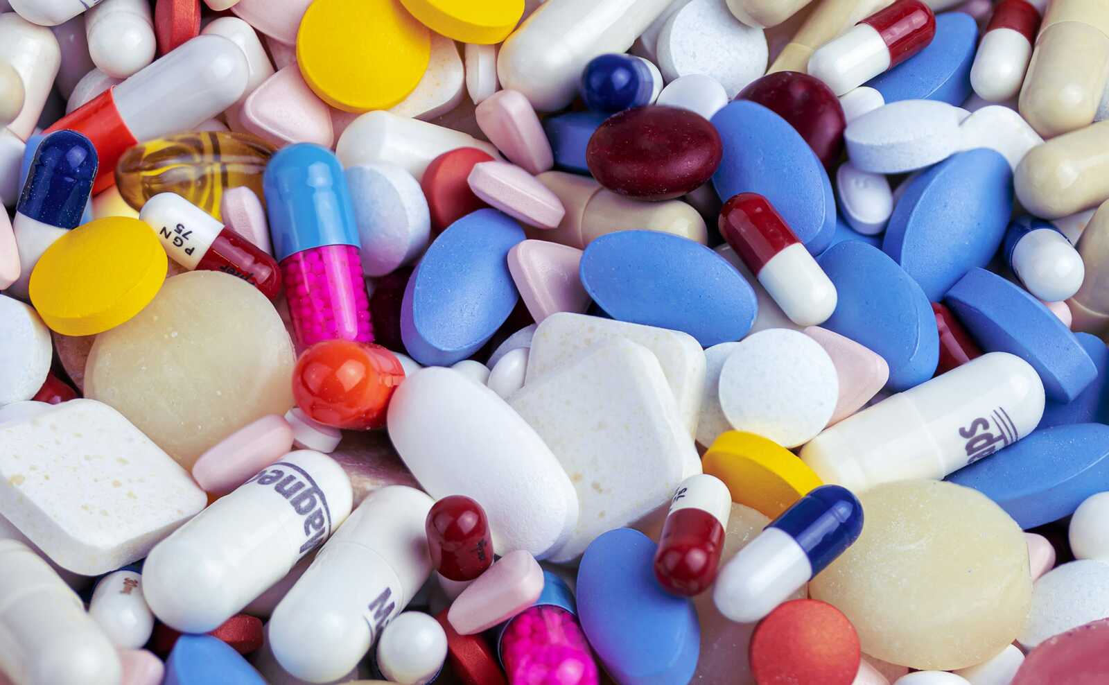 Mix of pills and medications (Photo by Myriam Zilles on Unsplash) | ALXnow Assorted pills, capsules, and tablets in various colors and shapes scattered together.
